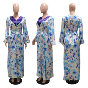 Detail of floral printed satin kaftan with deep V-neck and decorative purple buttons