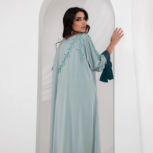 Détail d'une abaya turquoise élégante avec broderie de perles et accents dorés