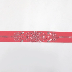 Vue détaillée de la bande élastique rose corail ornée d'élégants motifs floraux en strass