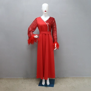 Dettaglio dell'abito rosso con paillettes con polsini in piume e scollo a V