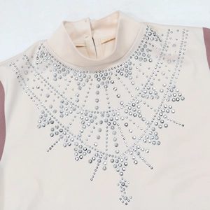 Dettaglio di motivi a onde con strass e collo alto sull'abito in raso beige