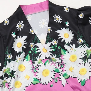 Detail of the V-neck collar showing pink lining and white daisy print on black fabric