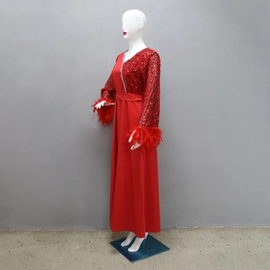 Dettaglio dei ricami di paillettes e dei polsini di piume su questo abito rosso