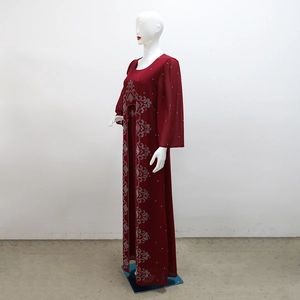Détail d'une robe maxi en mousseline bordeaux ornée de motifs complexes en strass argent