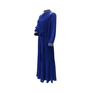 Détail de robe plissée bleu marine avec strass argentés sur les épaules et les poignets