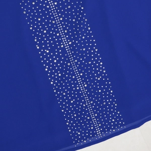Vue détaillée du tissu en mousseline bleu roi avec des ornements en strass verticaux