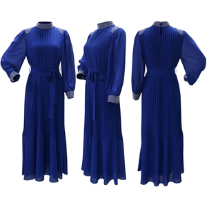 Détail d'une robe de soirée plissée bleu roi ornée de strass et de perles délicates