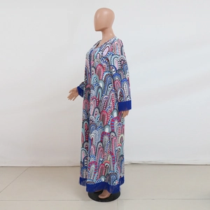 Gedetailleerd beeld van een boho maxi-jurk met kleurrijke print en kwastjes aan mouwen