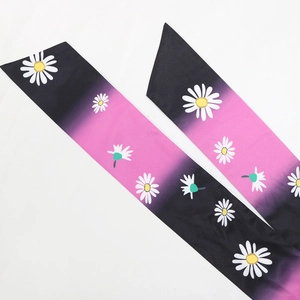 Detailed view of floral printed silk scarfs with black and pink gradient daisy pattern