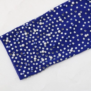 Detail of navy blue evening gown sleeve with silver rhinestones and faux pearls