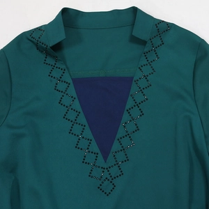 Detail of dark green robe neckline with navy triangle patch and black rhinestone patterns