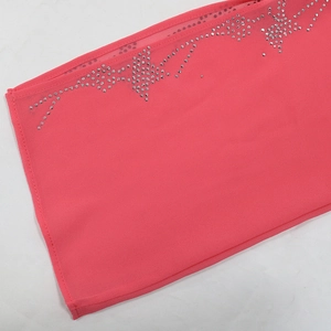 Detail von rosa Chiffon-Abendkleid mit glitzernden Strasssteinen am Saumrand