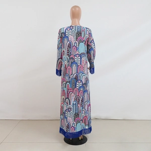 Detail van meerkleurige jurk met geometrische print en diepblauwe kwastjes aan de mouwen