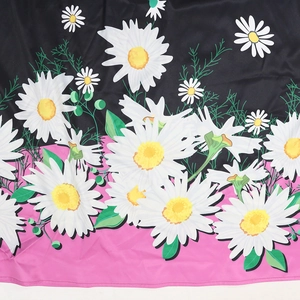 Detail of floral print fabric featuring white daisies on black and pink contrast background