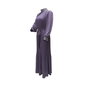 Détail du col montant perlé et de la robe plissée violette avec des strass délicats
