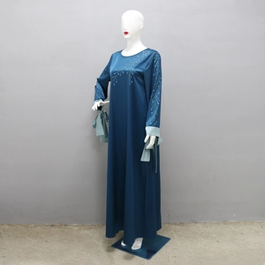 Détails des motifs floraux en strass et poignets contrastés sur robe abaya en satin