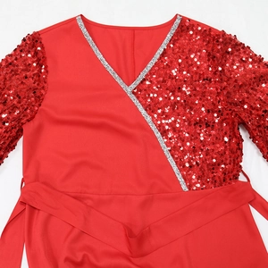 Dettaglio dell'abito rosso con scollo a V, bordo argento e ricami di paillettes rosse
