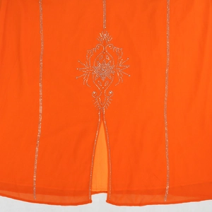 Détail des strass argentés étincelants sur le tissu en mousseline orange vif