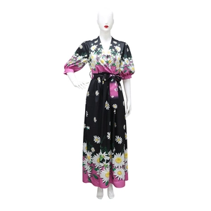 Detail of V-neckline and white daisy floral print on a black and pink long dress