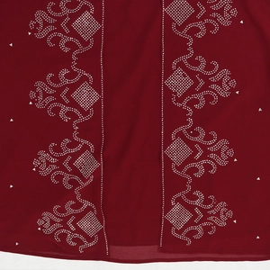 Vue détaillée d'une robe en mousseline rouge foncé avec motifs en strass argentés
