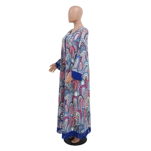 Detail van een bohemien maxi-jurk met blauwe franjes aan de mouwen en de onderste zoom
