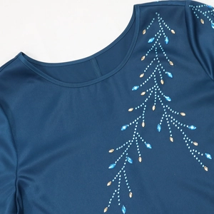 Détail de la robe en satin bleu marine avec motifs de branches en strass et paillettes