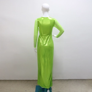 Detail view of emerald green gown showing beadwork on sheer sleeves and metallic fabric