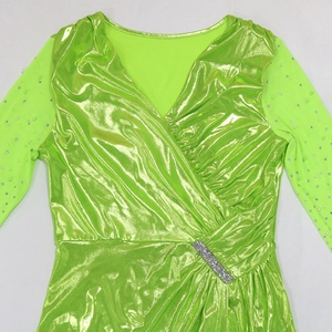 Detail of neon green gown featuring sheer mesh sleeves with pearls and rhinestone accents