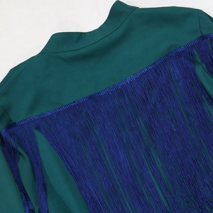 Detailed close-up of vibrant blue silk tassels on the back of a deep green robe dress