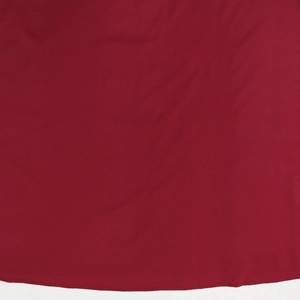 Vue macro montrant la texture fine du tissu en mousseline bordeaux sur la robe