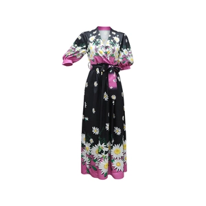 Detail of V-neck and bubble sleeves on a black maxi dress with daisy floral print