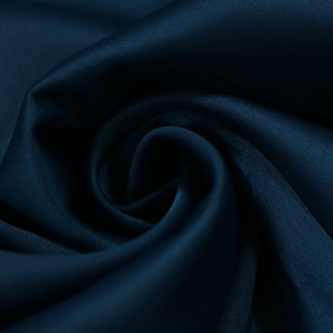 Macro di tessuto satinato blu scuro con lucentezza elegante e consistenza setosa