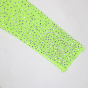 Detail of neon green mesh dress sleeves with silver rhinestones and white pearls