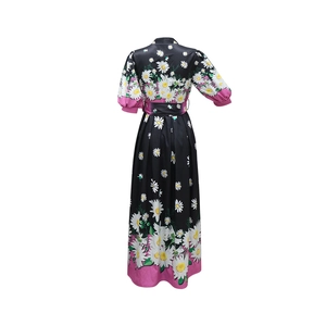 Detail view of pink cuffs on black long dress with white daisy floral pattern