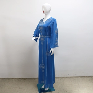 Détails d'une robe en mousseline bleu roi avec strass argentés et manches longues