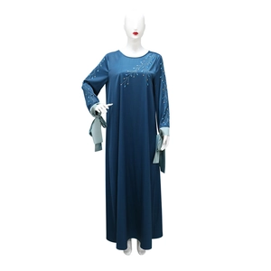 Détails de motifs de feuilles en strass et poignets en ruban de satin vert sur une abaya