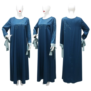 Détails de broderie sur robe en satin bleu marine avec poignets contrastés à nœuds bleus