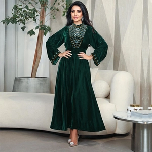 Elegant emerald velvet long sleeve evening gown with intricate beaded neckline and cuffs