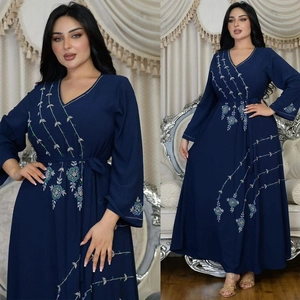 Detail of navy blue long sleeve dress featuring silver vine and green floral embroidery