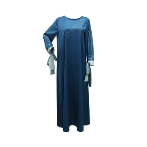 Détail de l'abaya en satin bleu marine avec motifs de feuilles en strass dorés et nœuds