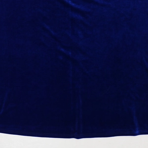 Detailed view of dark blue velvet fabric featuring precise hemline stitching and soft texture