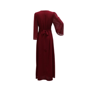 Détail de l'arrière d'une robe longue en mousseline rouge foncé avec ceinture à nouer