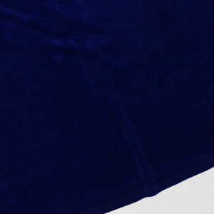 Macro shot of dark blue velvet fabric showing soft texture and precision edge stitching