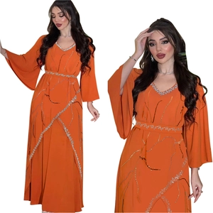 Detail of bright orange chiffon maxi dress with rhinestone patterns and flared sleeves