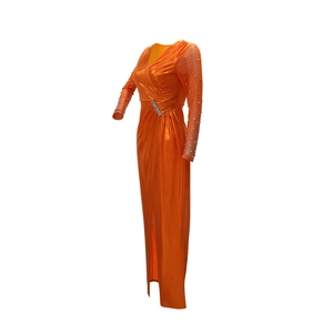 Detail of orange evening gown featuring beaded waist pleats and sheer sequined sleeves
