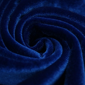 Detailed macro view showing the luxury texture of dark green velvet fabric with gloss