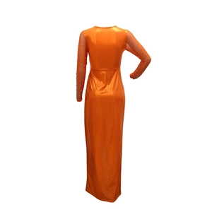 Detailed back view of orange evening gown with sheer rhinestone sleeves and slit