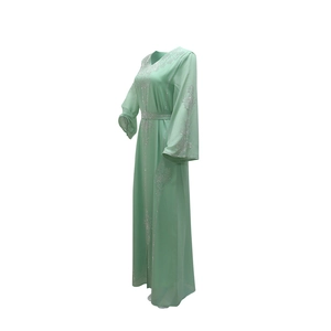Détail de robe en mousseline vert clair avec col en V et broderies de paillettes argentées