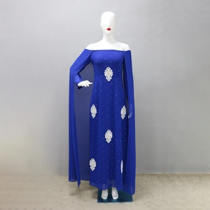Détail de la robe en mousseline bleu roi avec fleurs en dentelle blanche et strass brillants