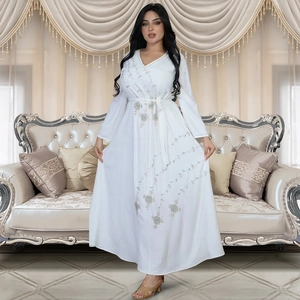 Detail of white long-sleeved dress featuring intricate floral embroidery and V-neckline